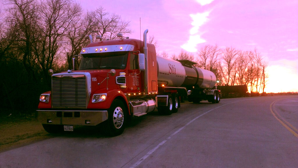 Skinner Transportation bulk tanker truck on a Texas highway at sunset